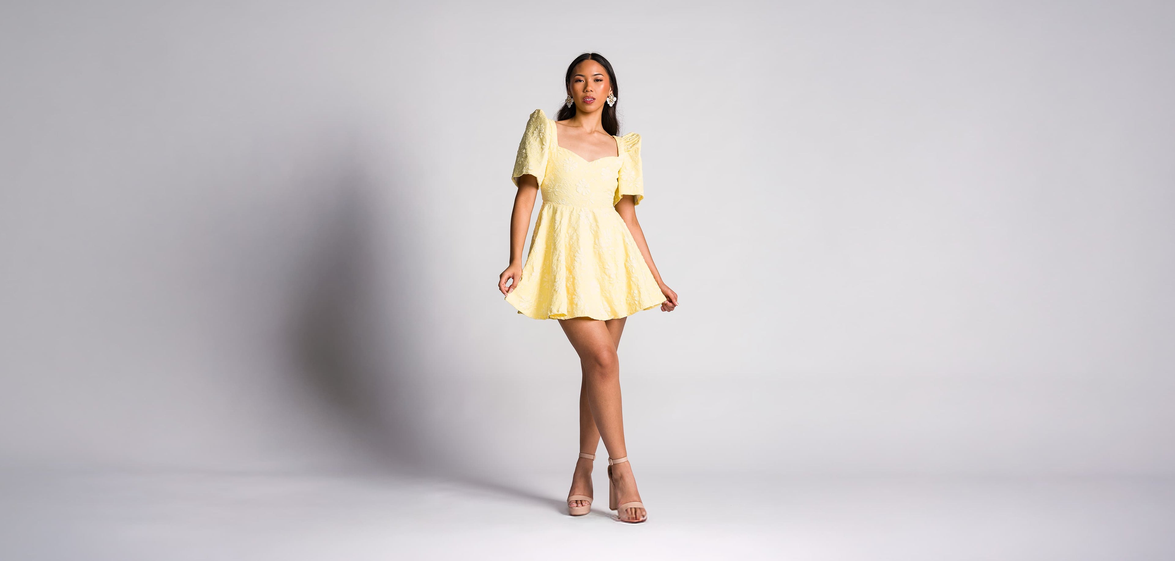 Woman wearing a pastel yellow filipiniana mini dress with butterfly sleeves