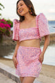 Woman wearing a pink sequin Filipiniana terno by a waterfront