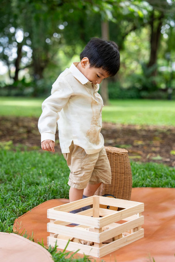 Child wearing Antonito Barong Tagalog in cream – traditional Filipino formalwear for boys while playing in the park