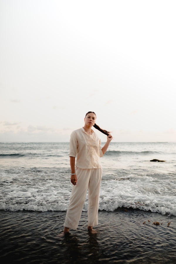 Modern Filipina wearing Barong Tagalog shirt in cream at the beach – cultural outfit inspiration